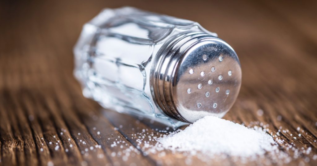 Old wooden table with a Salt Shaker (close-up shot; selective focus)
